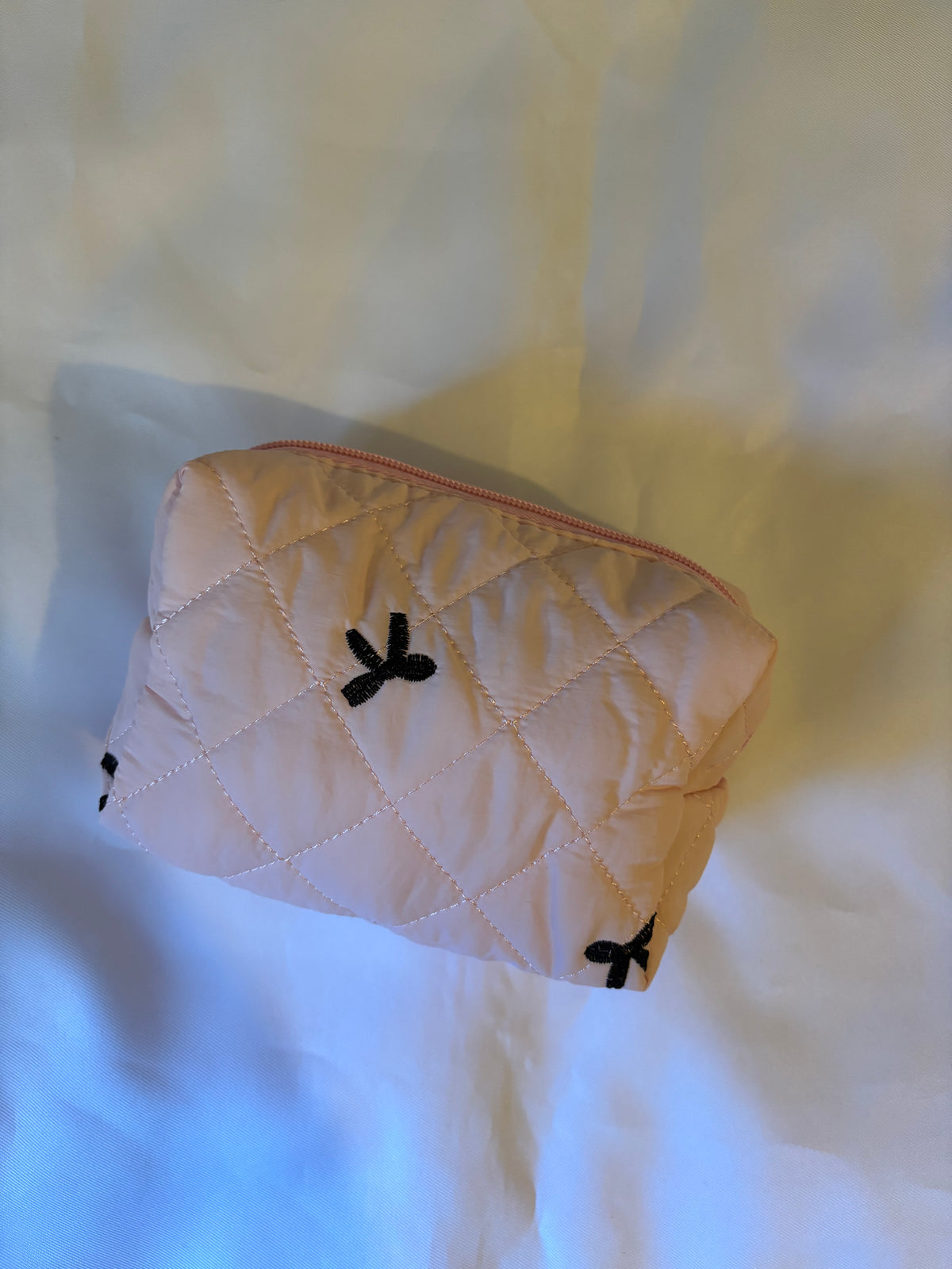 Trousse matelassée rose à nœuds noirs